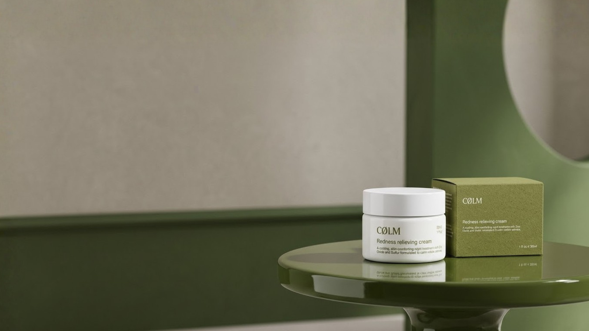 CØLM Redness Relieving Cream og dens æske på et grønt bord